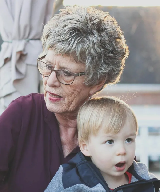 A grandmother sitting with her young grandson